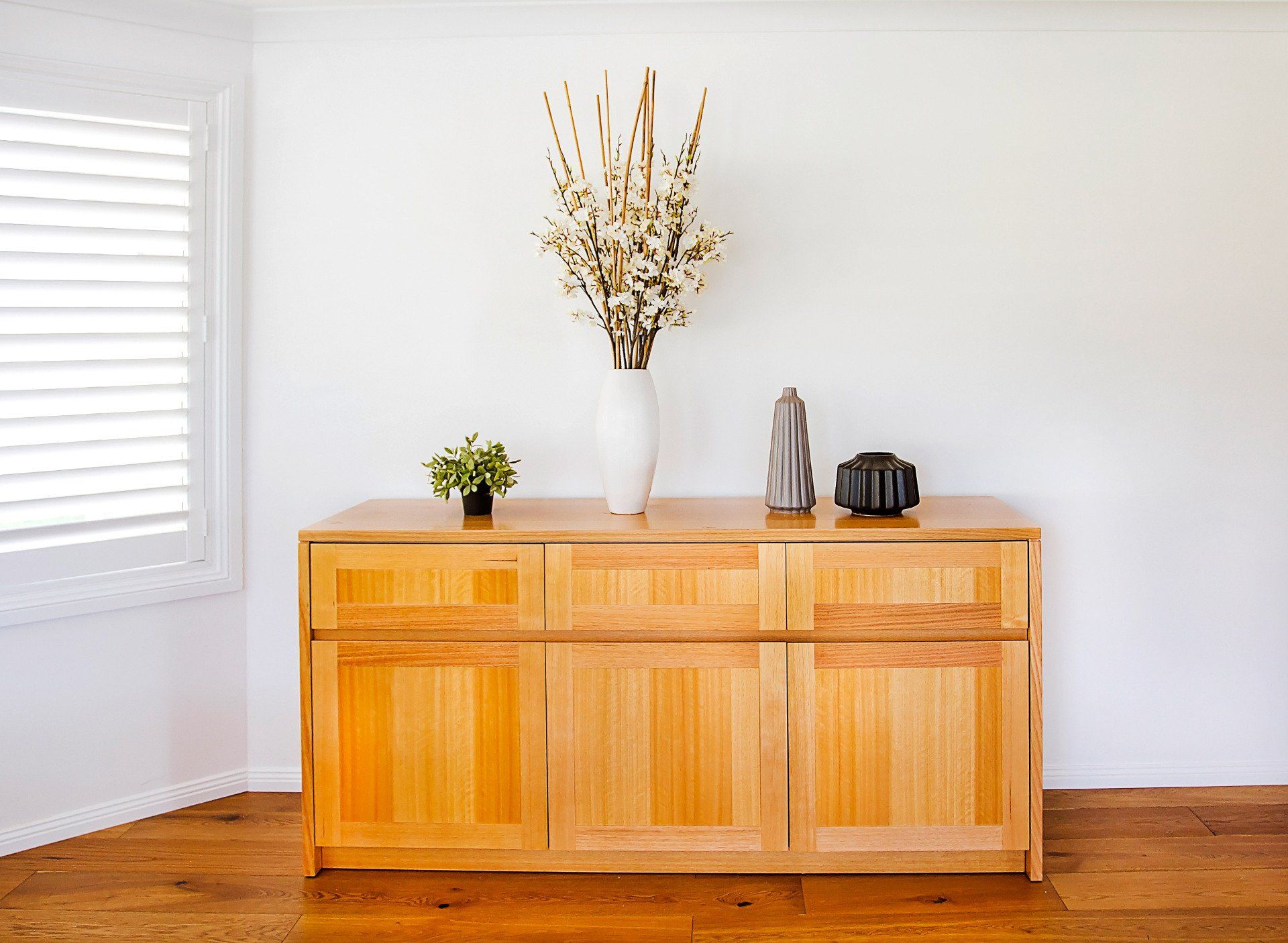A Wooden Cabinet With A Vase Of Flowers On Top Of It — Marlix Custom Timber Furniture Design and Joinery in Unanderra, NSW