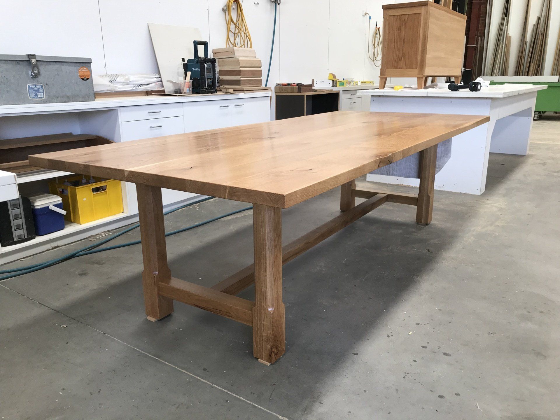 A Wooden Table Is Sitting On A Concrete Floor In A Room — Marlix Custom Timber Furniture Design and Joinery in Unanderra, NSW