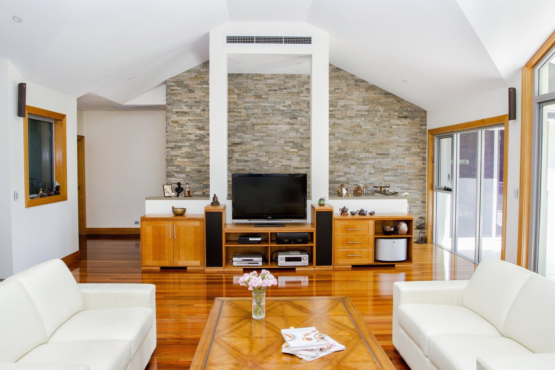 A Living Room With Two White Couches And A Flat Screen Tv — Marlix Custom Timber Furniture Design and Joinery in Unanderra, NSW