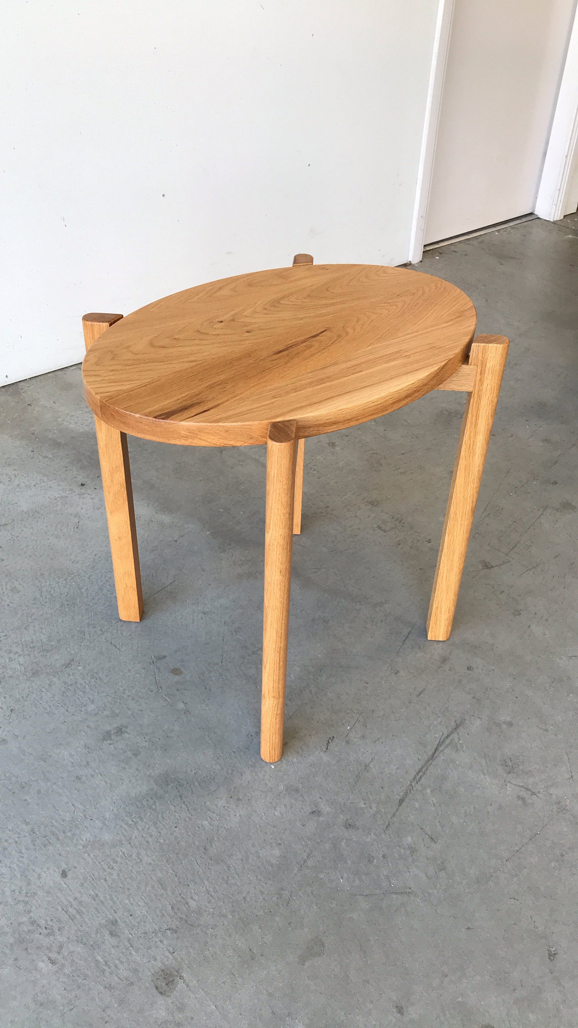 A Small Wooden Table Is Sitting On A Concrete Floor — Marlix Custom Timber Furniture Design and Joinery in Unanderra, NSW