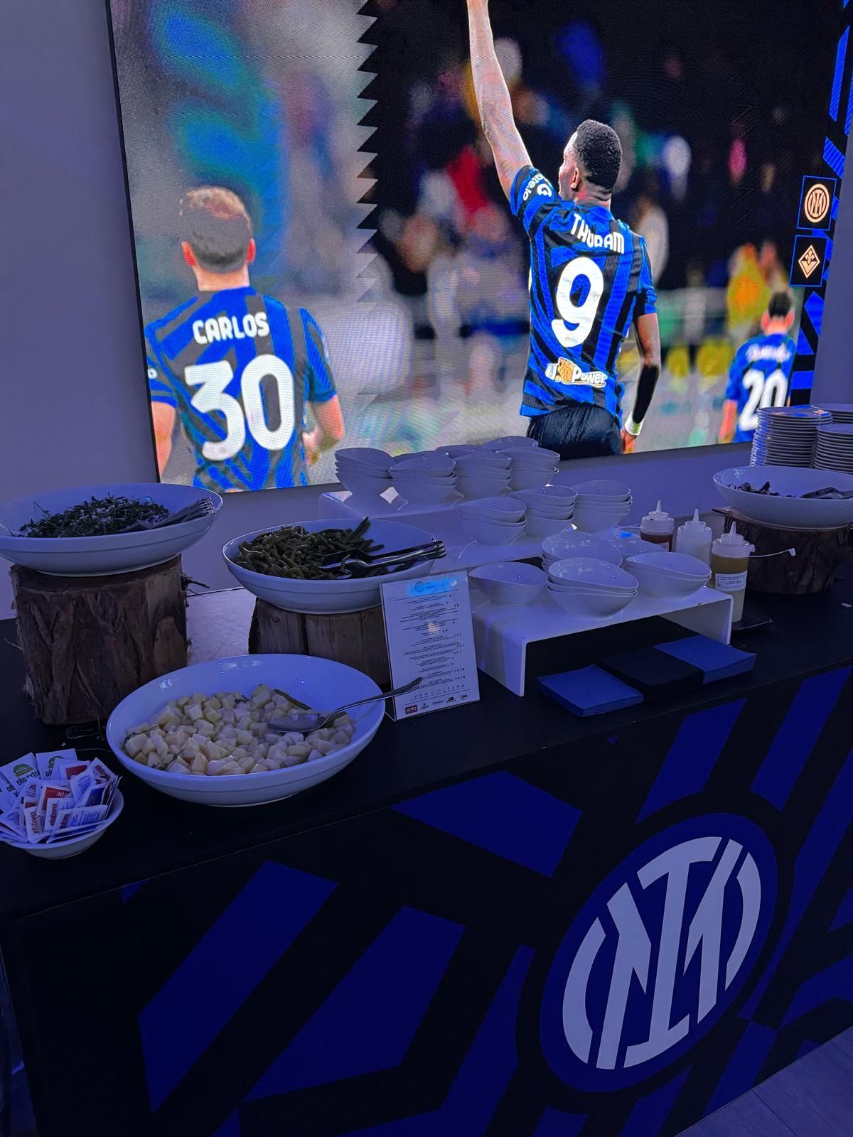Tavolo da pranzo con sfondo di una partita di calcio; logo dell'Inter sul tavolo.