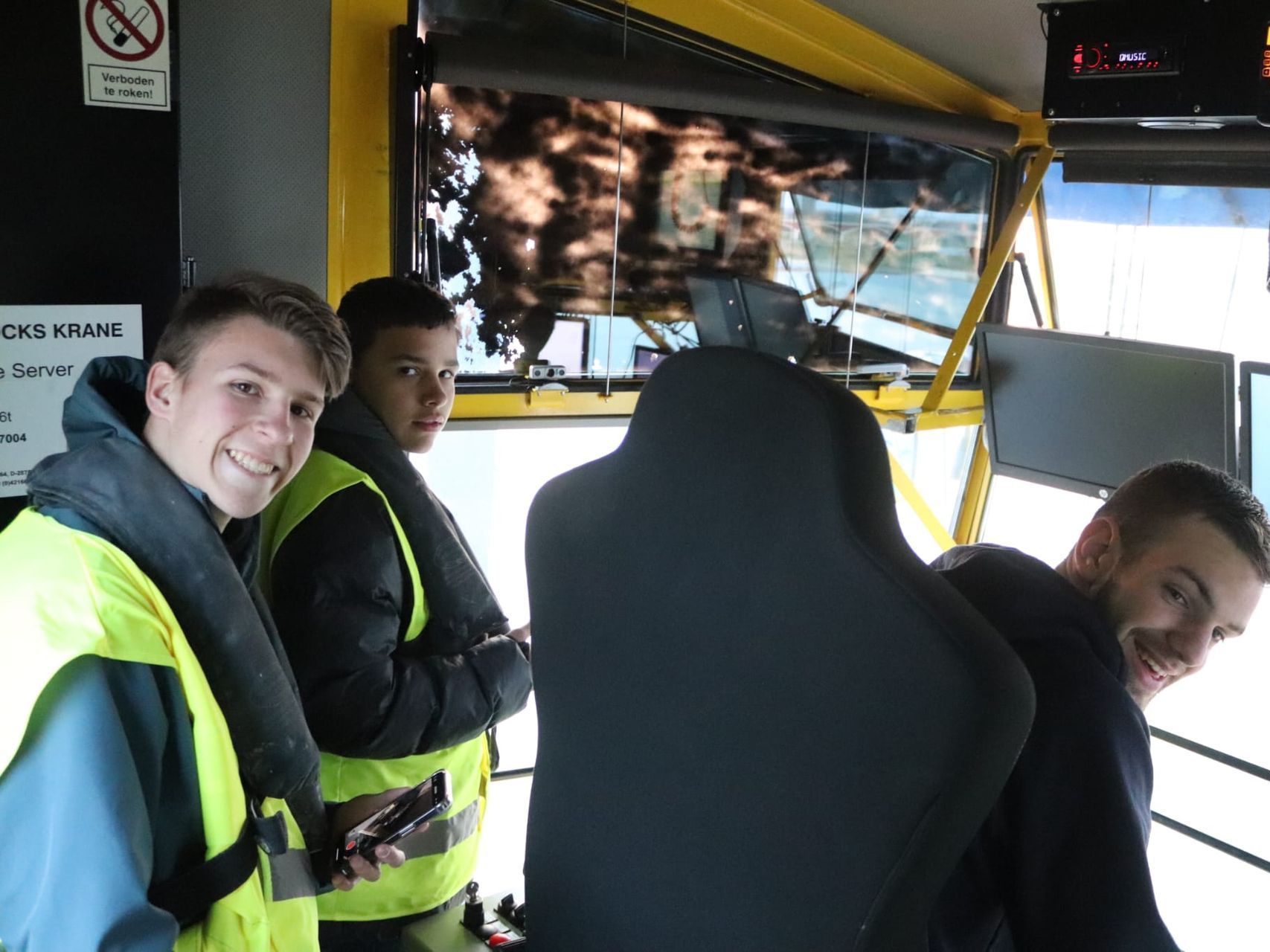 Een groep jonge mannen met gele hesjes staat in een bus.