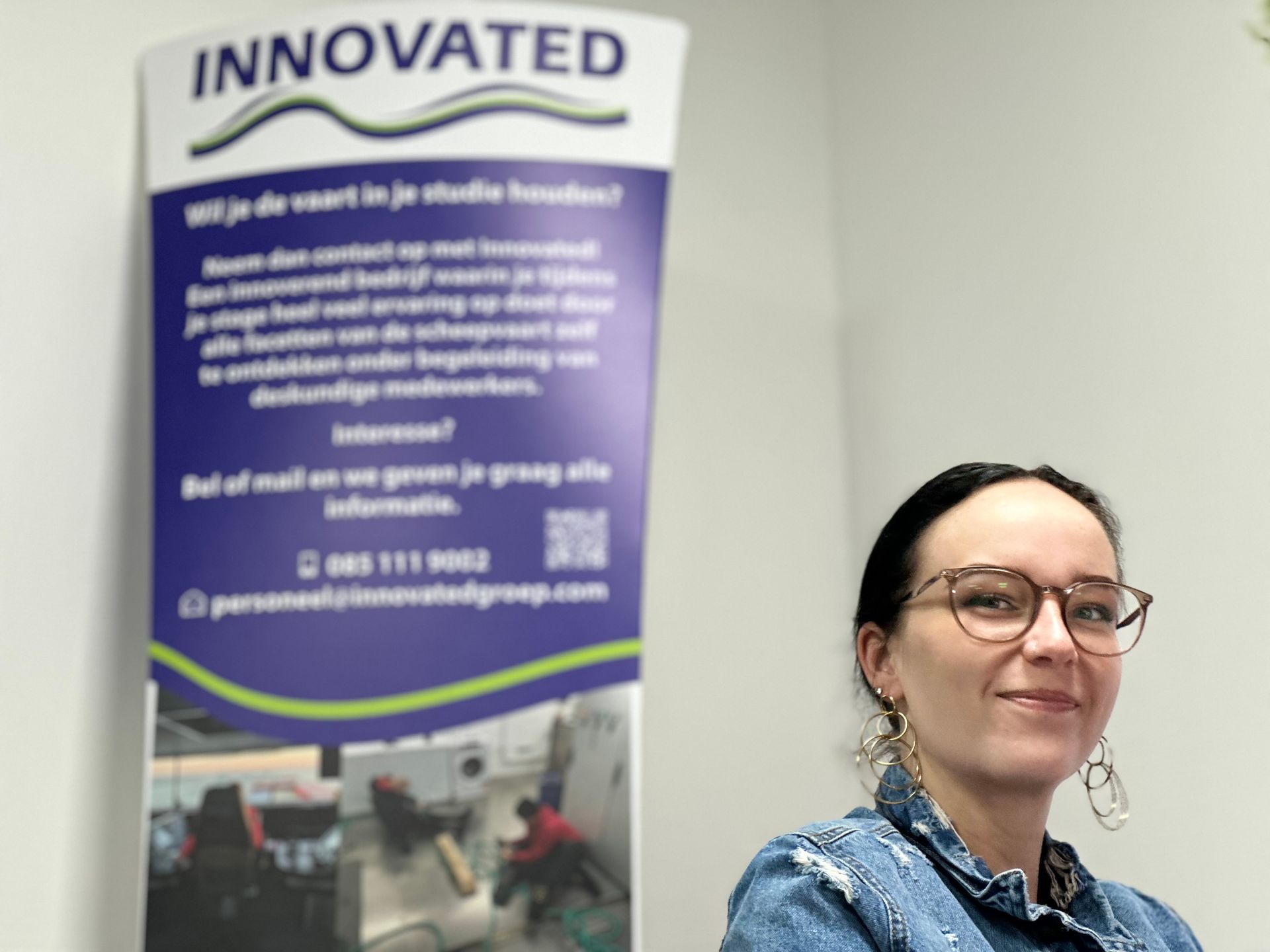 Een vrouw staat voor een spandoek met de tekst geïnnoveerd