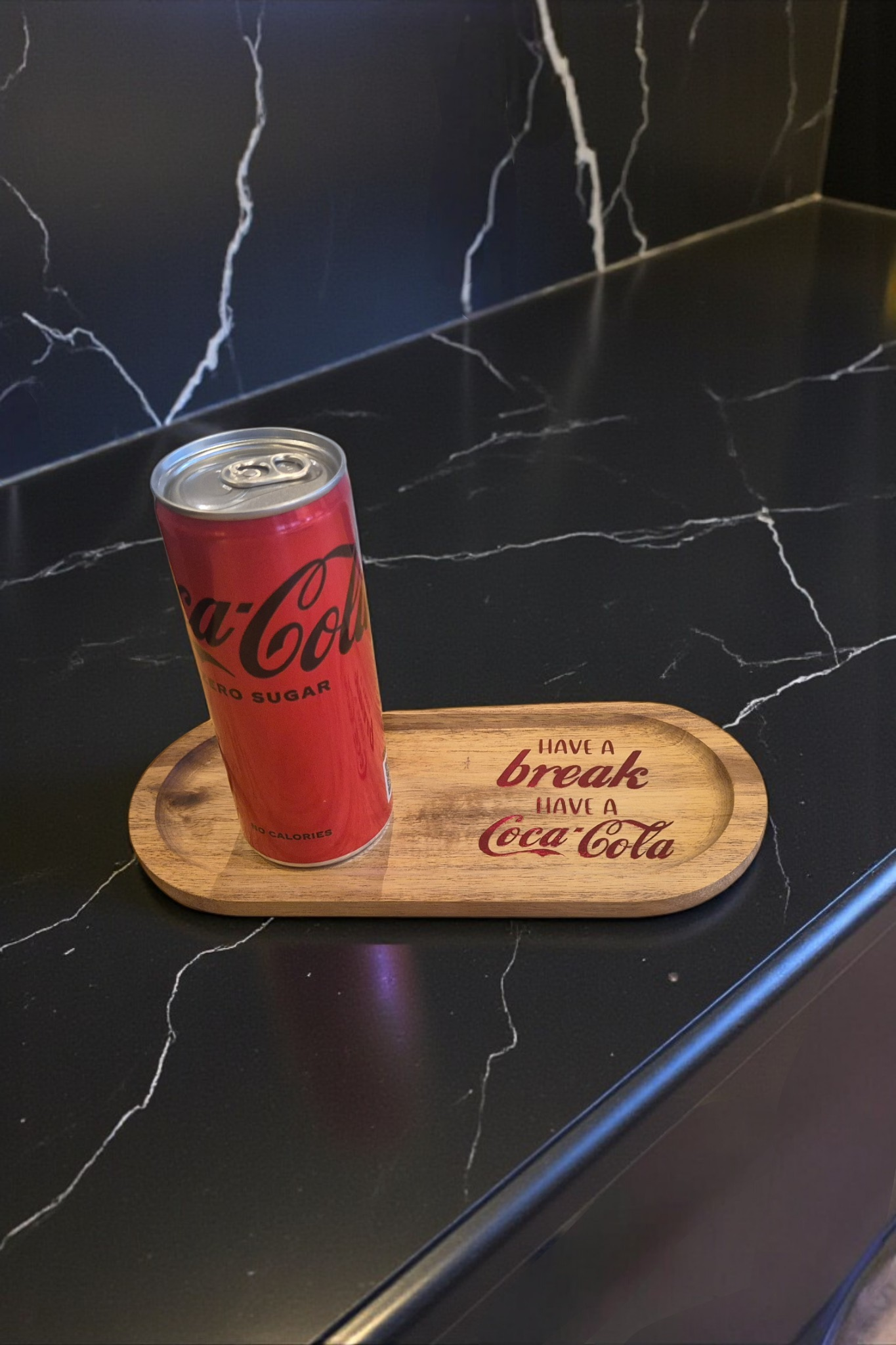 Een rood blikje Coca-Cola op een houten plankje met tekst.