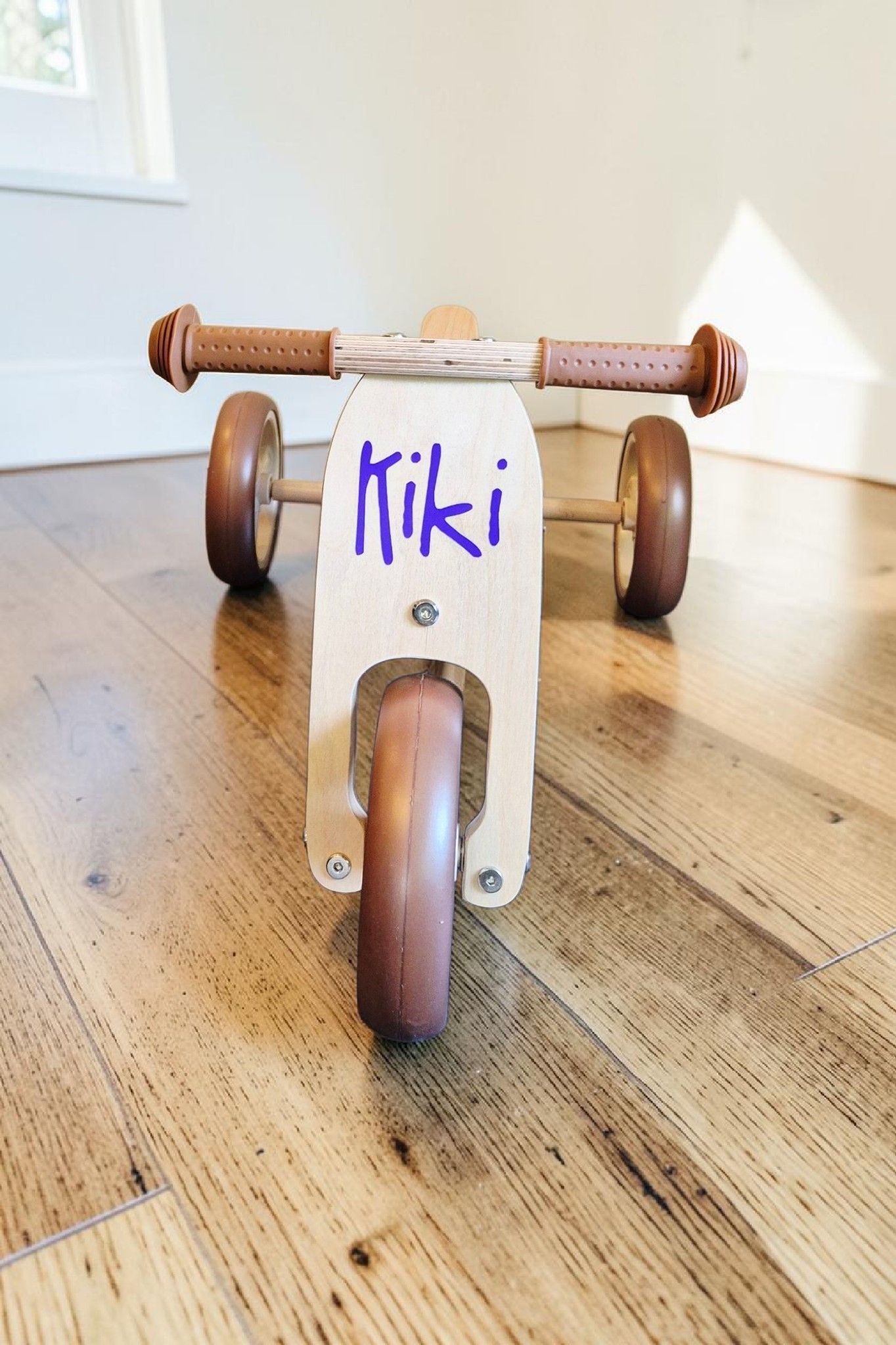 Houten driewieler met paarse bedrukking 