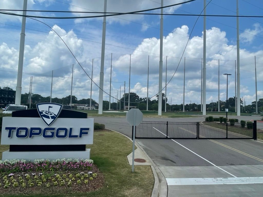 A sign that says topgolf in front of a golf course