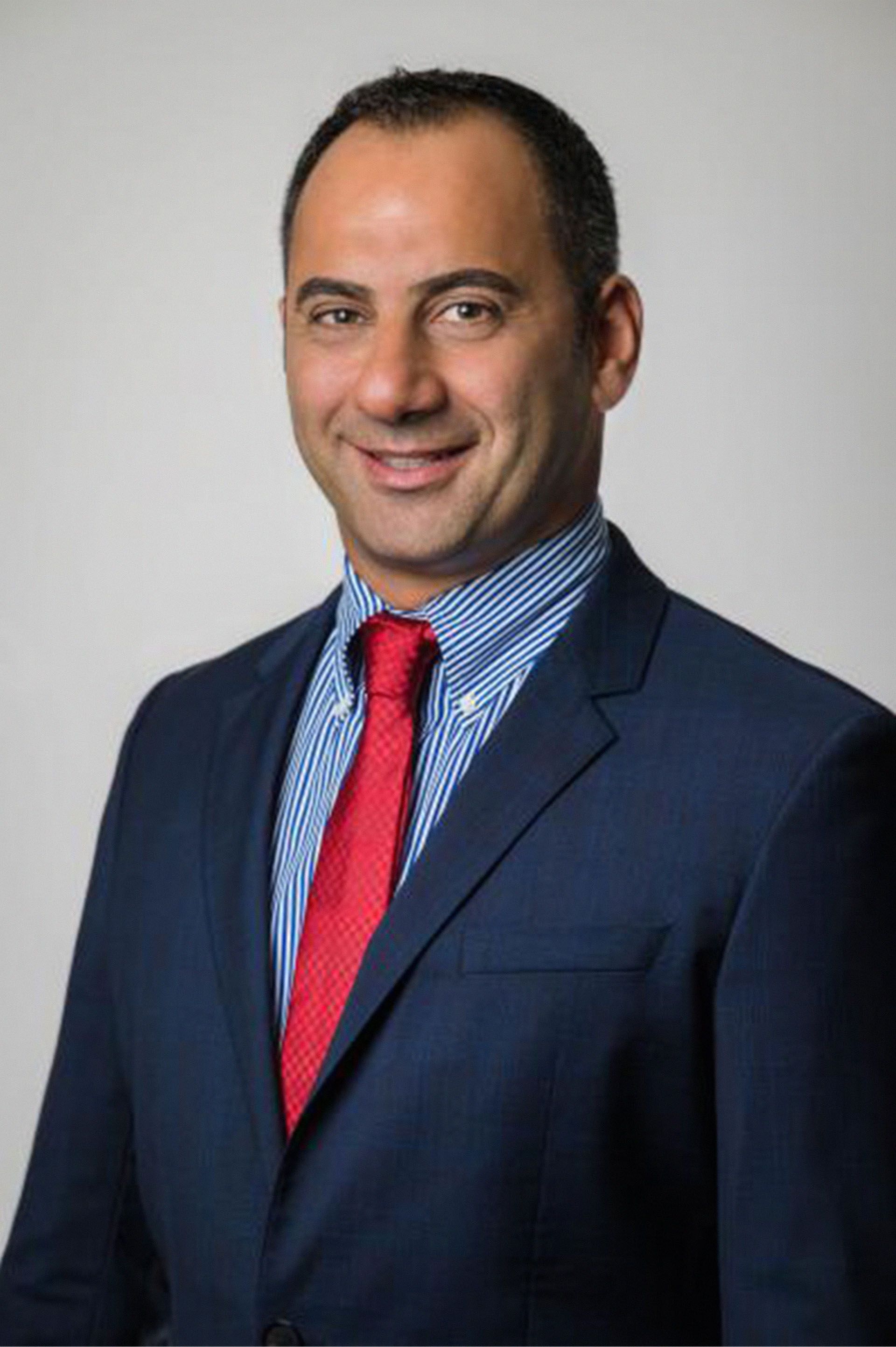 A man in a suit and tie is smiling for the camera.