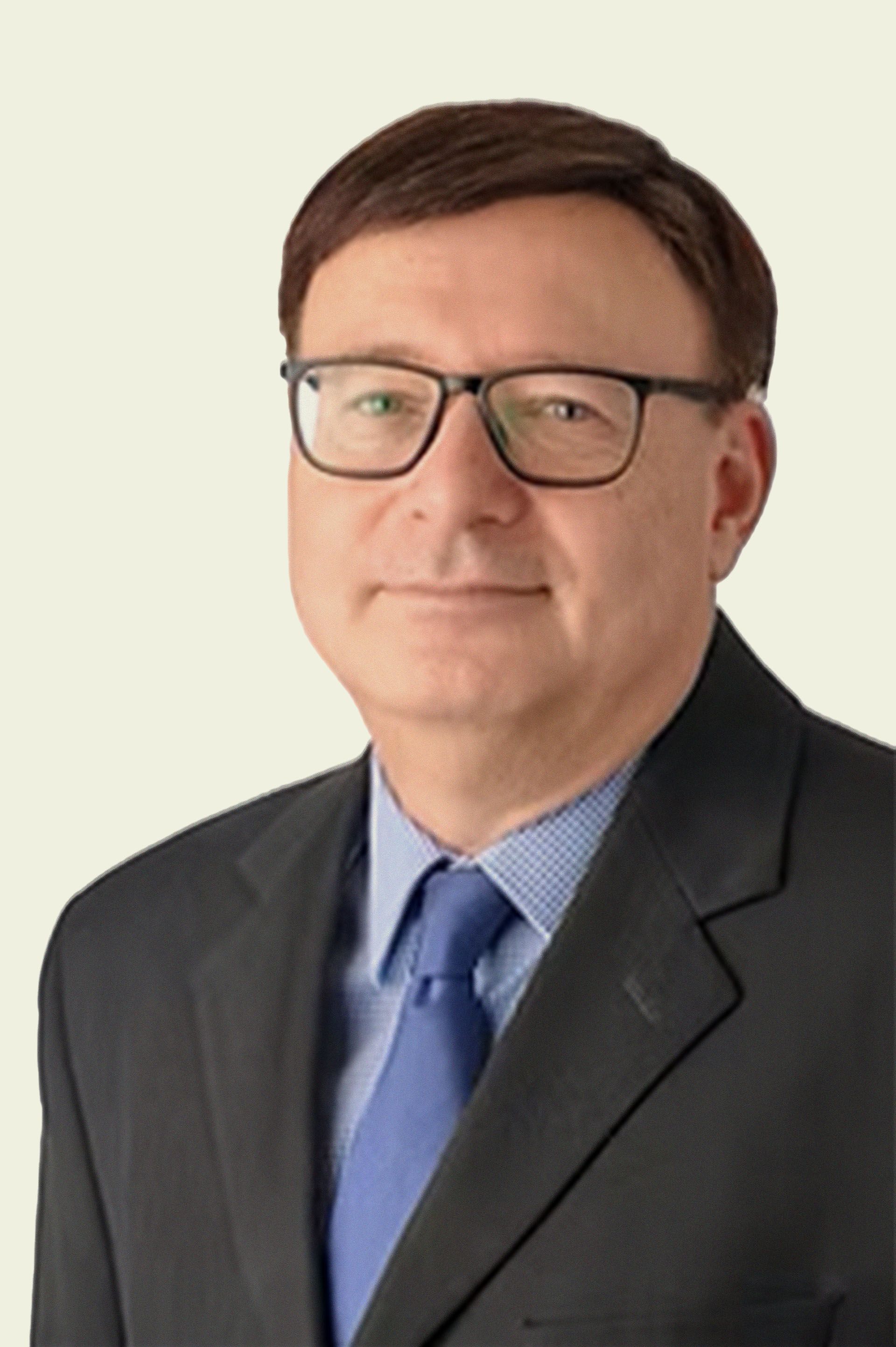 A man in a suit and tie is wearing glasses