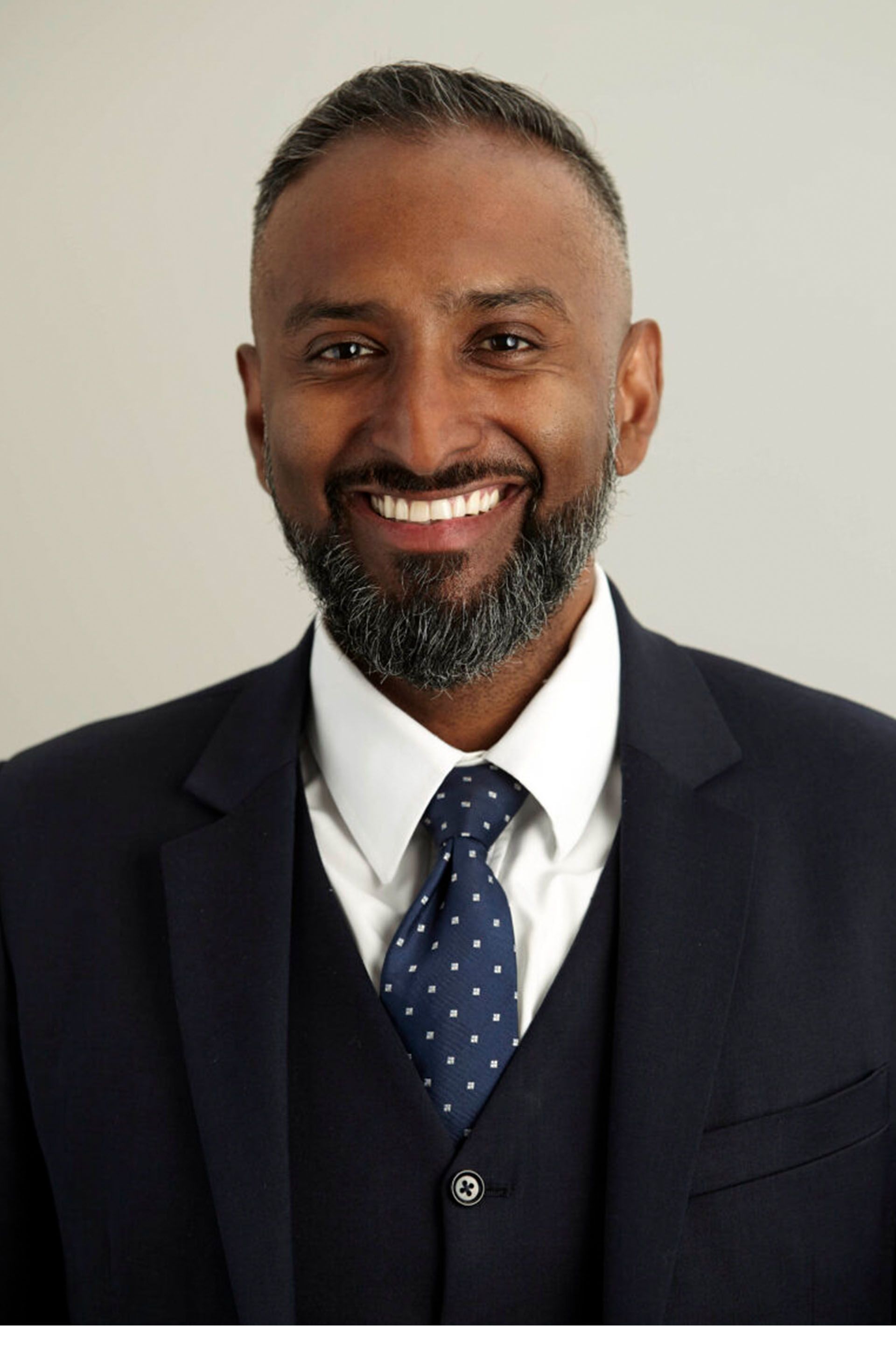 A man in a suit and tie is smiling for the camera.