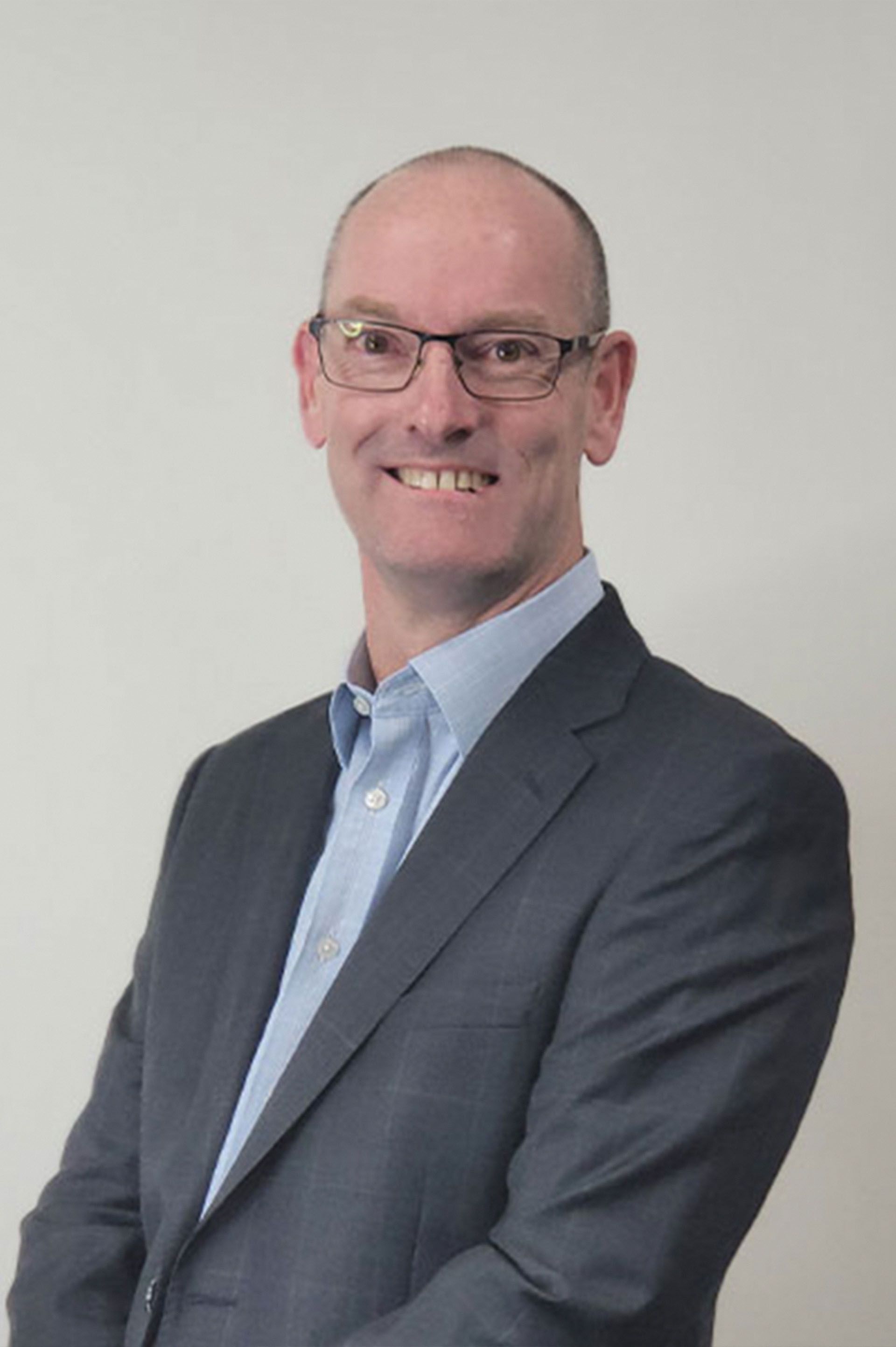 A man in a suit and tie is smiling for the camera.