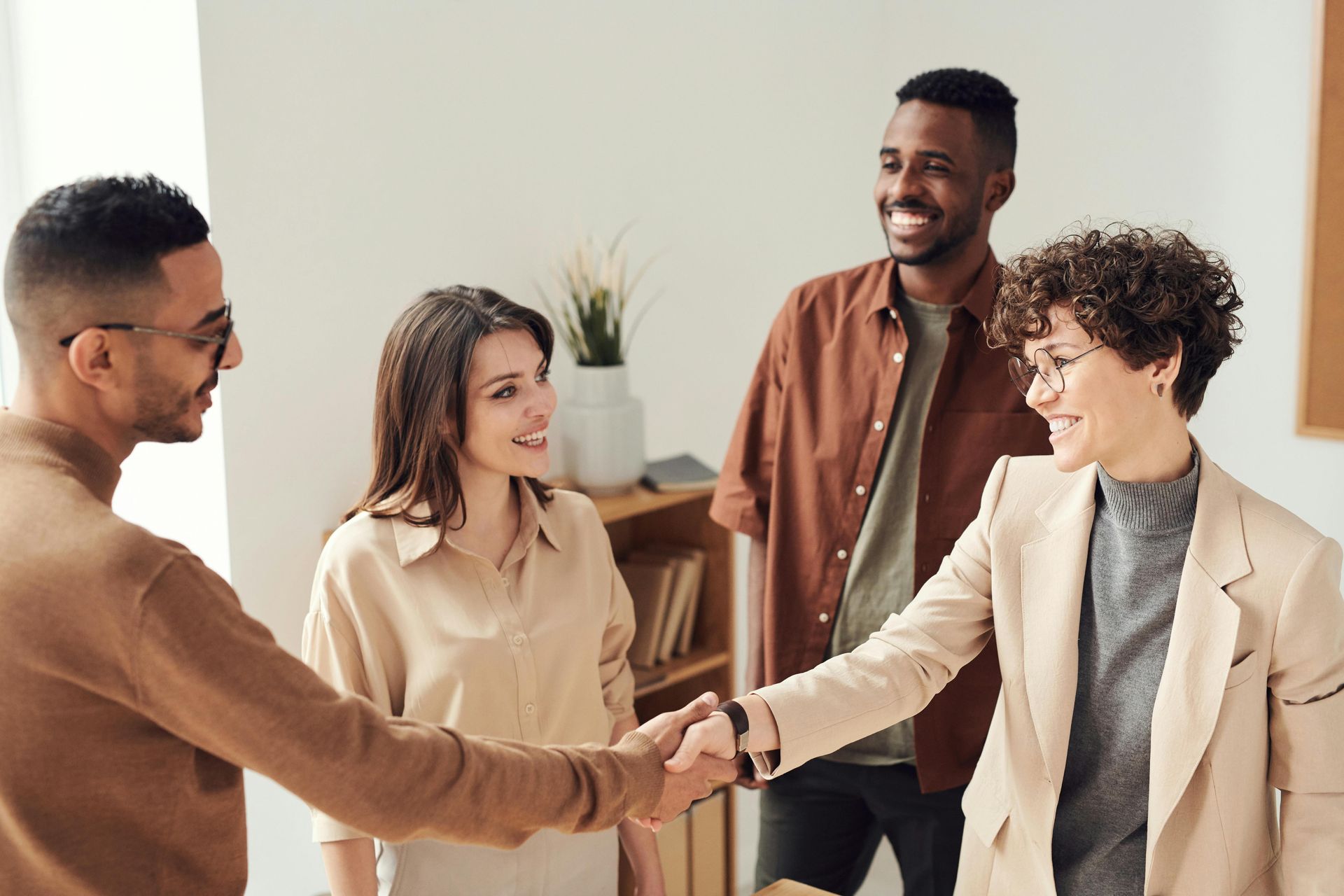 A group of people are shaking hands in a room.