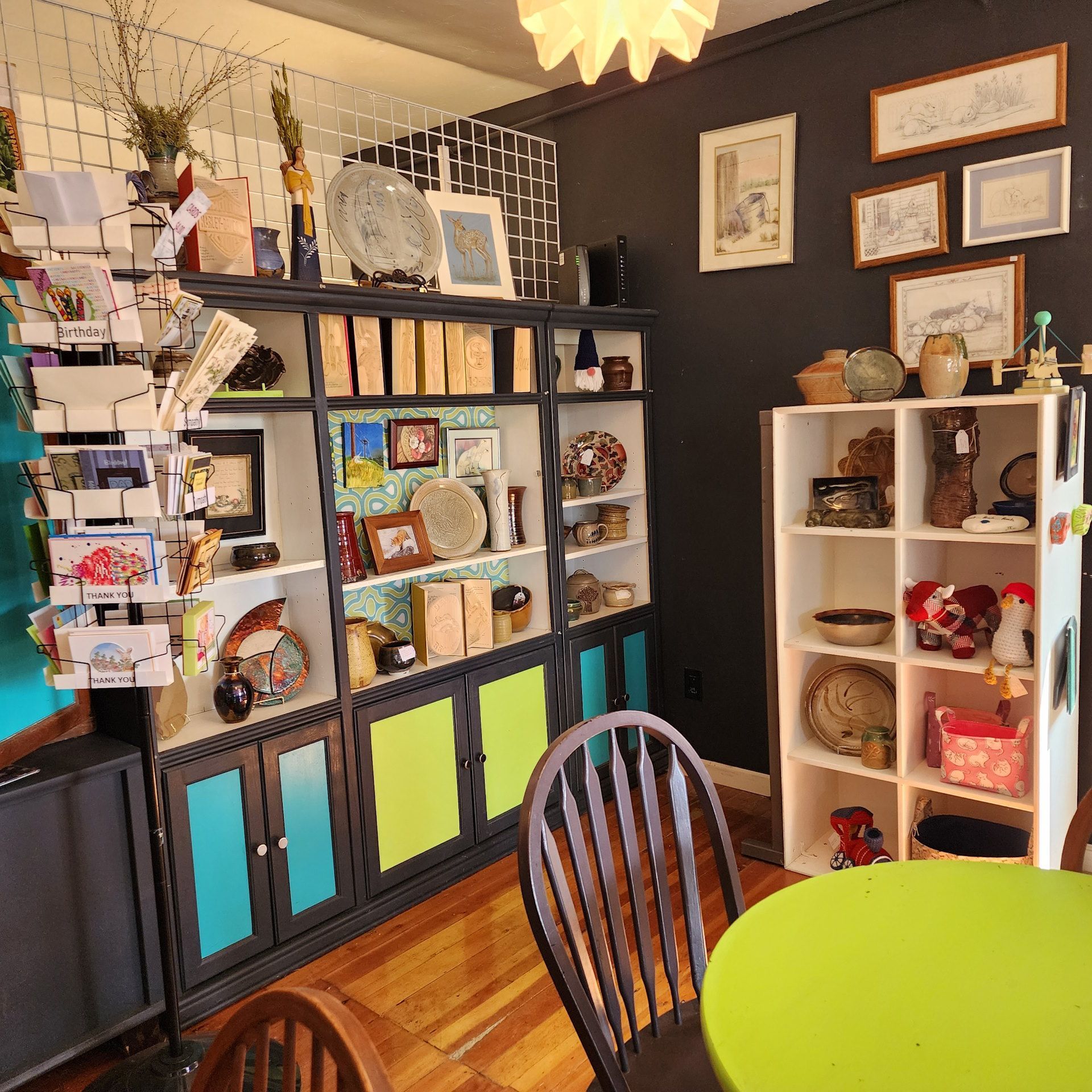 A room with a table and chairs and a shelf full of plates