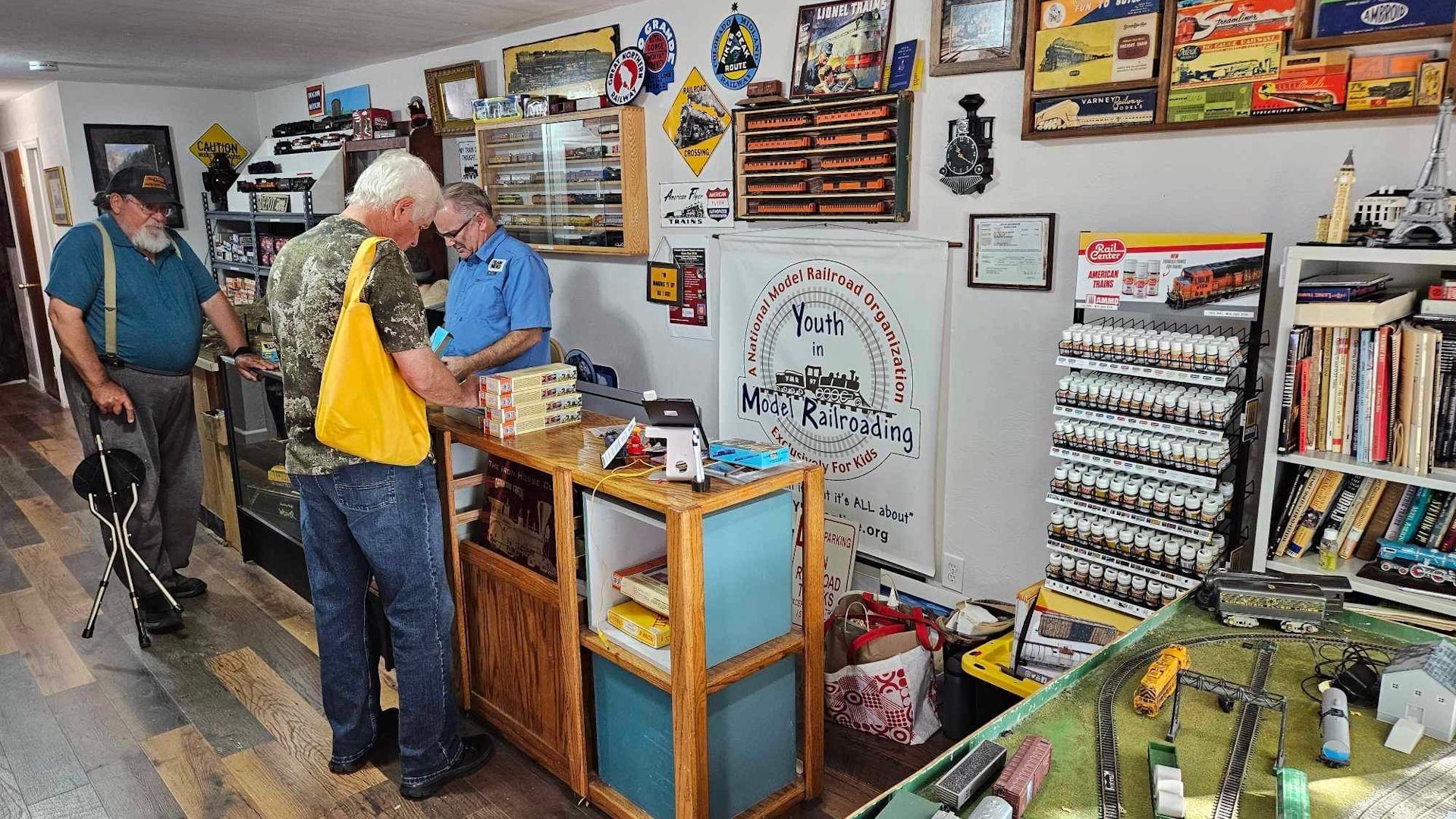 A group of men are standing around a counter in a store.