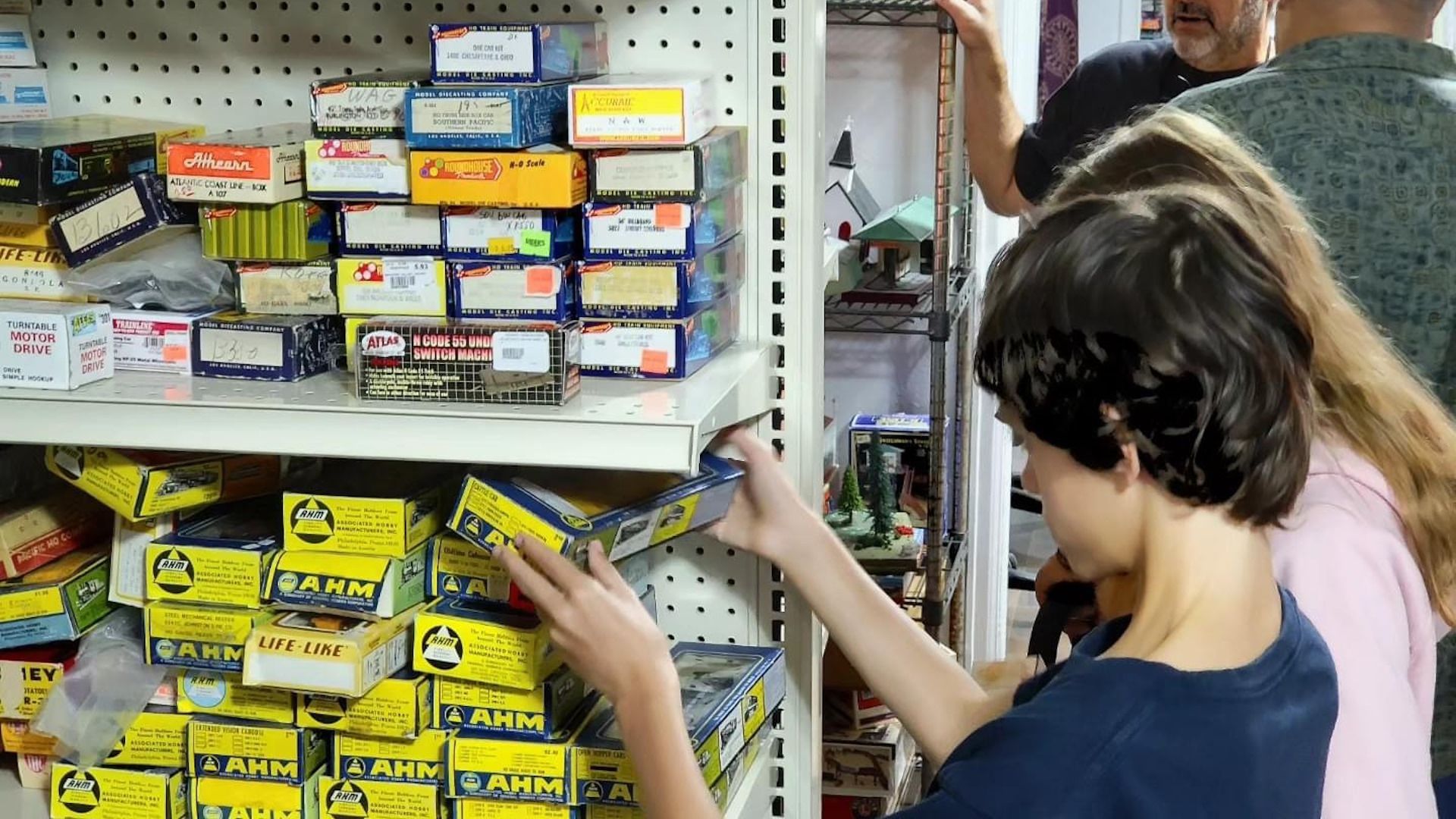 A group of people are looking at boxes on a shelf in a store.