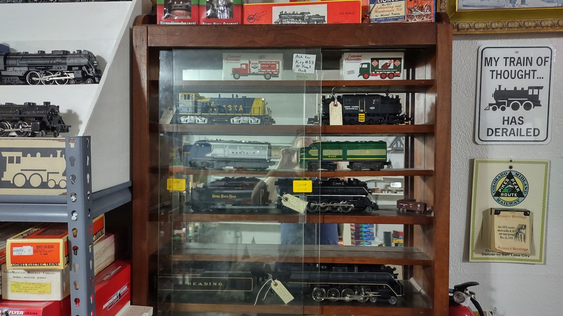 A display case filled with model trains and a sign that says my train is midnight has derailed