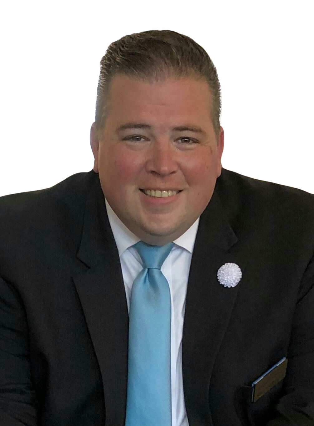 Portrait of a smiling man in a black suit with a light blue tie and white lapel pin on a white background