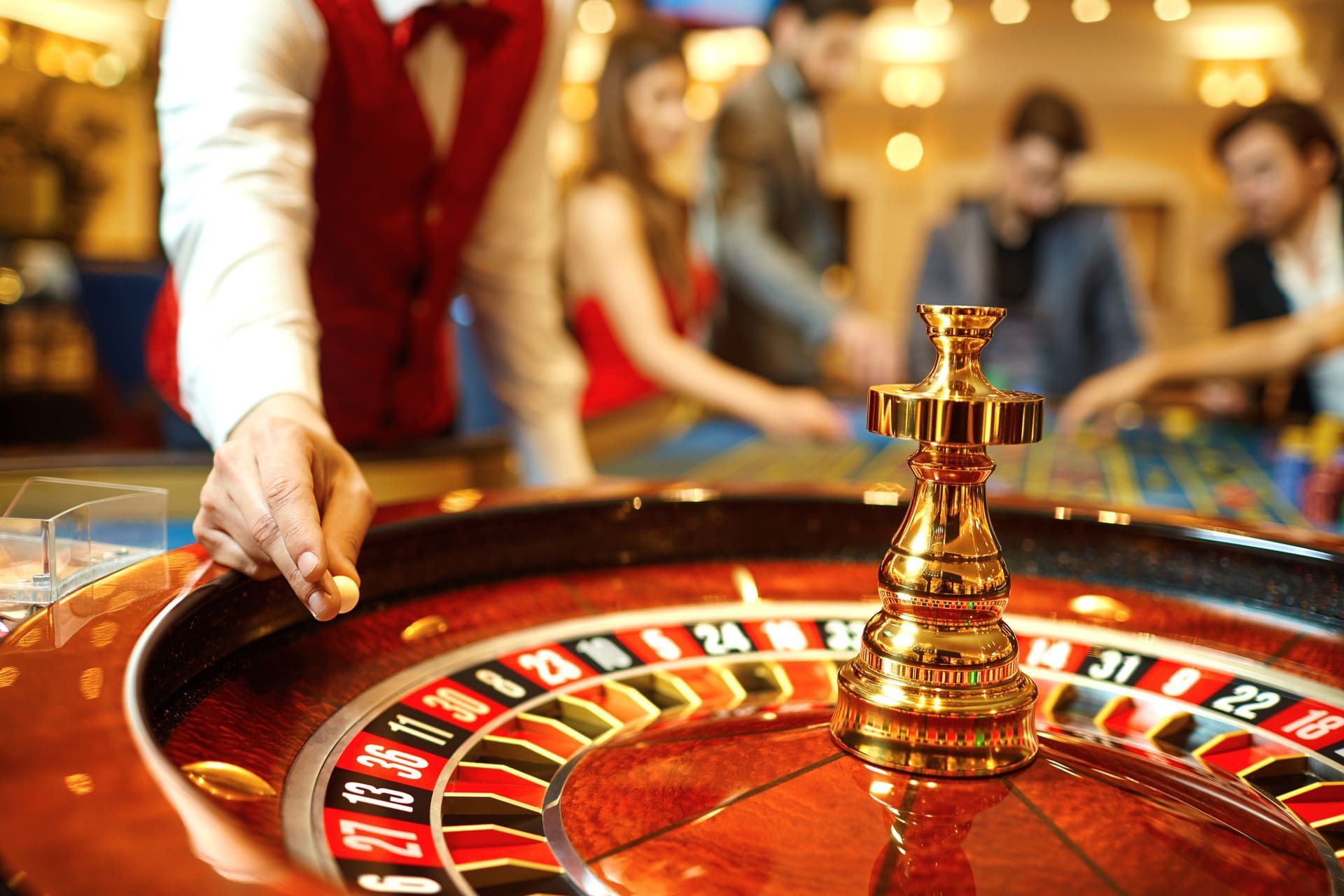 The croupier holds a roulette ball in a casino in his hand