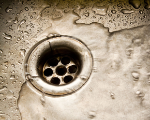 Cuatro obreros de la construcción en un tejado, trabajando en un edificio. Uno en una escalera, los demás con herramientas.