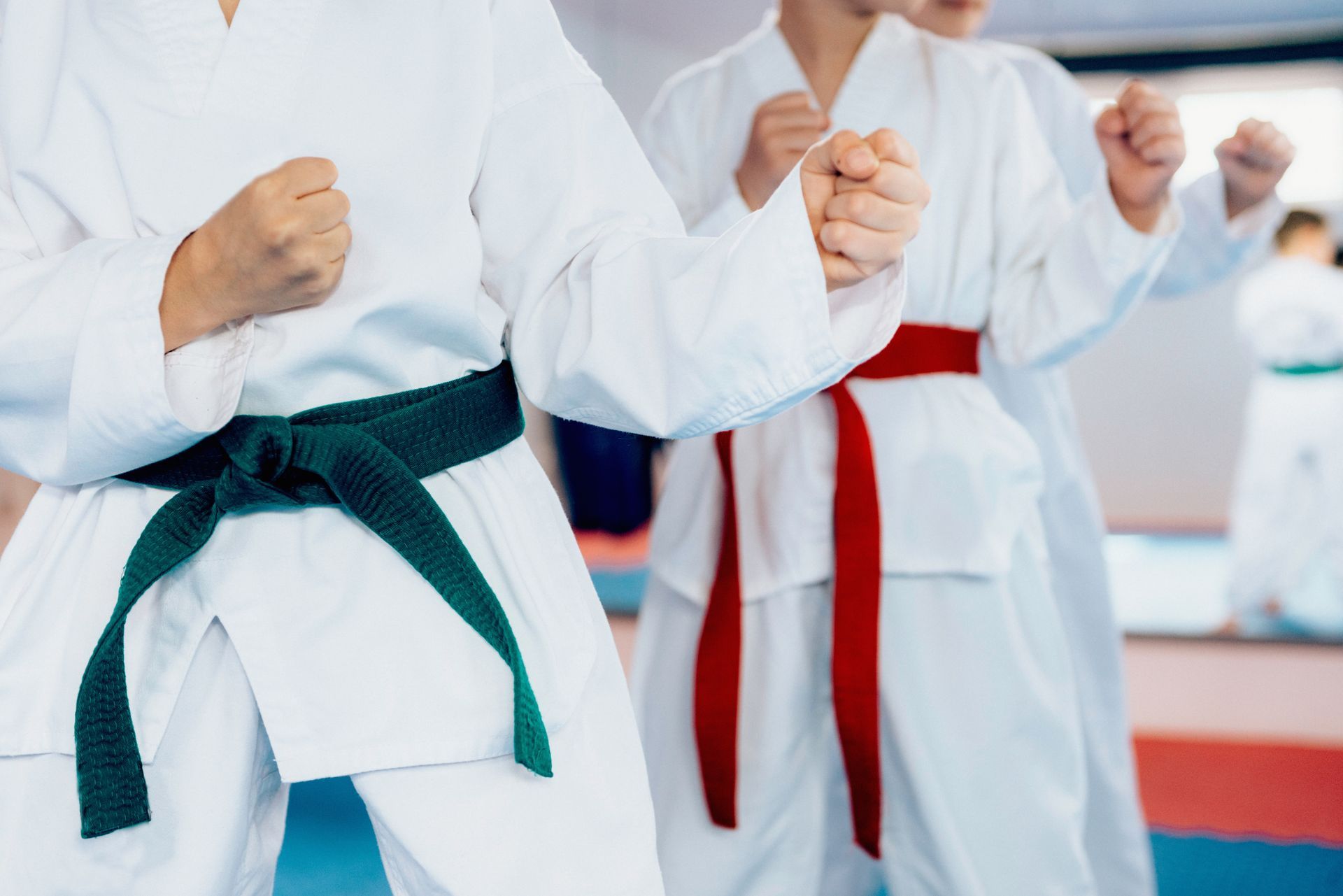 A group of young boys are practicing karate in a gym.