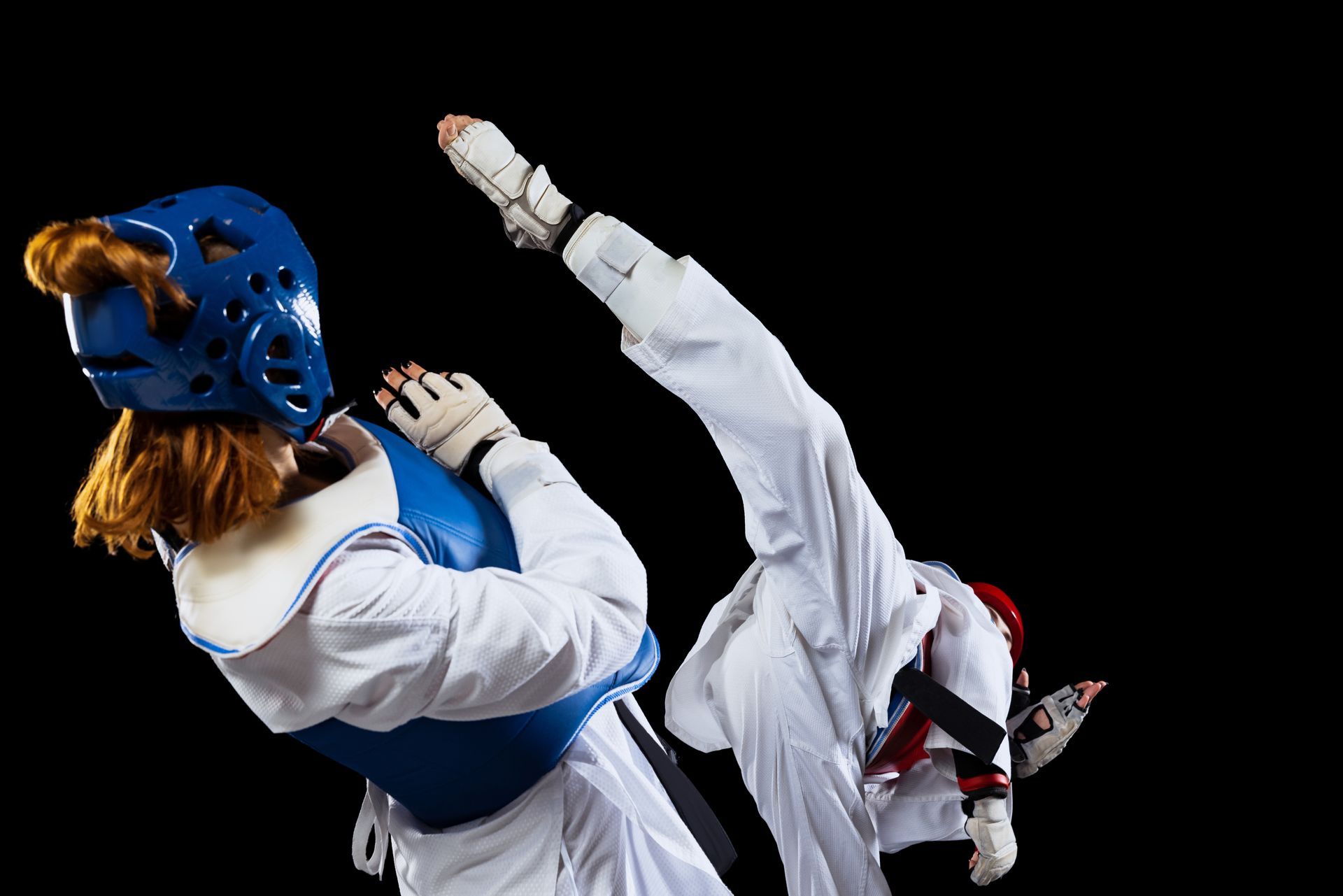 Two taekwondo fighters are fighting each other on a black background.
