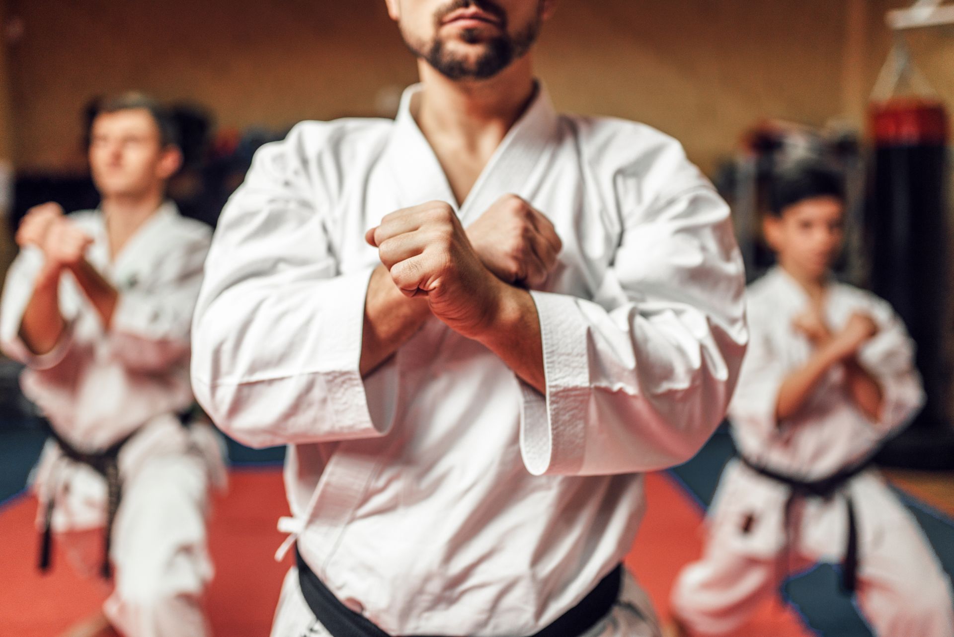 A group of men are practicing karate in a gym.