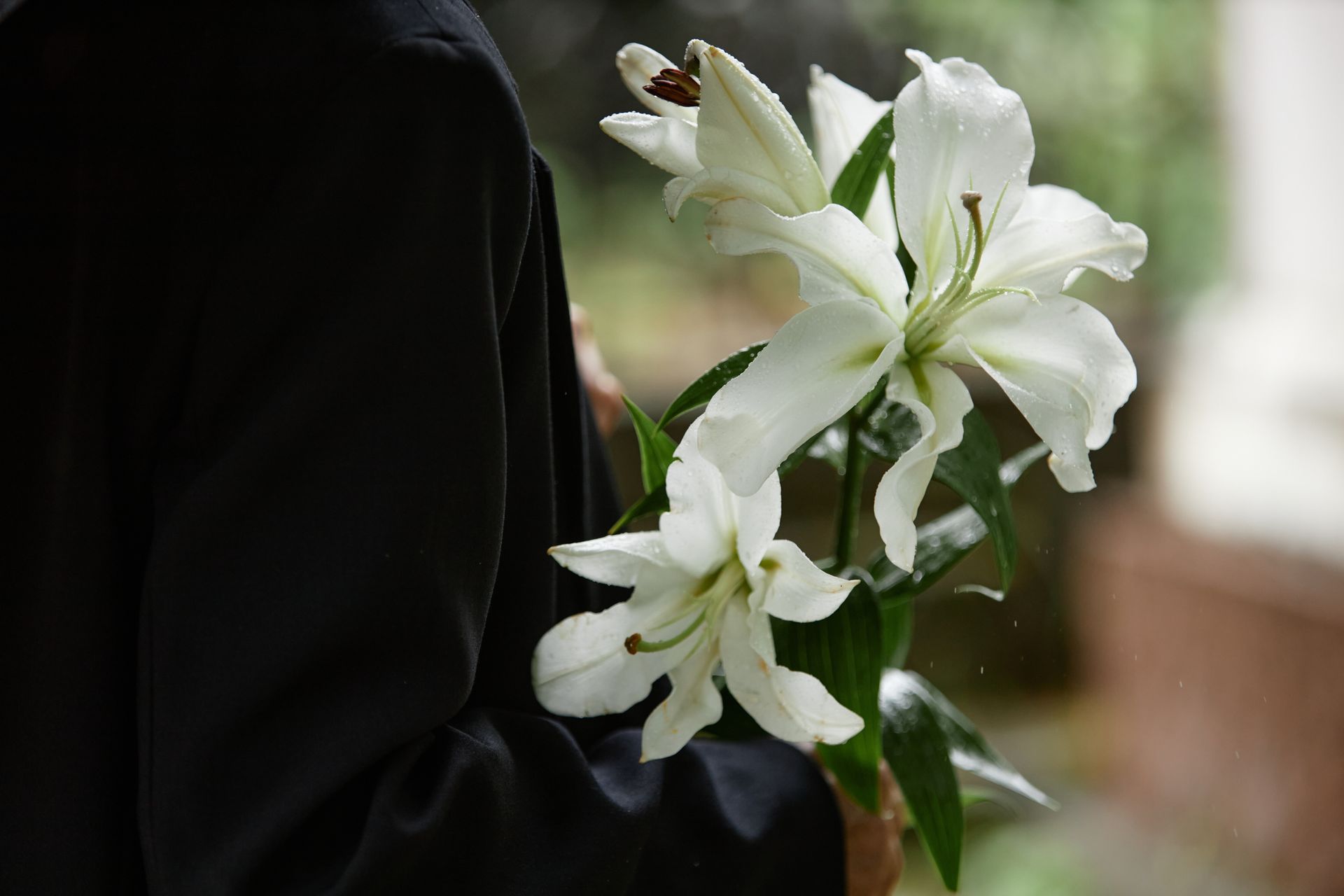 Person holding flowers at a funeral