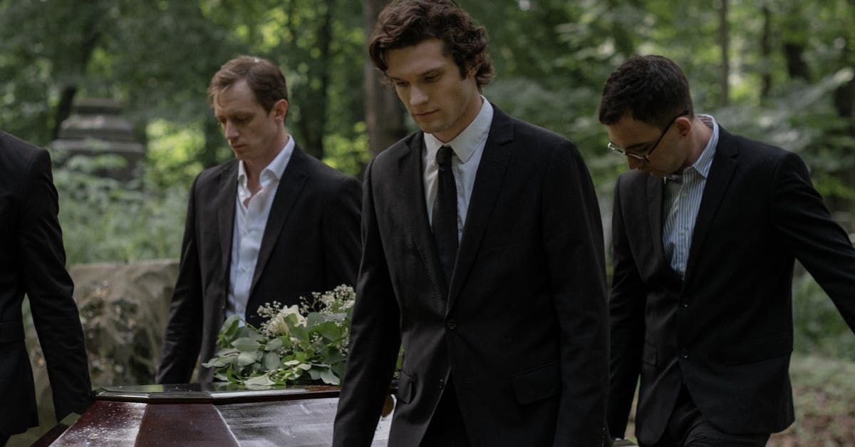 People in black suits carrying a casket