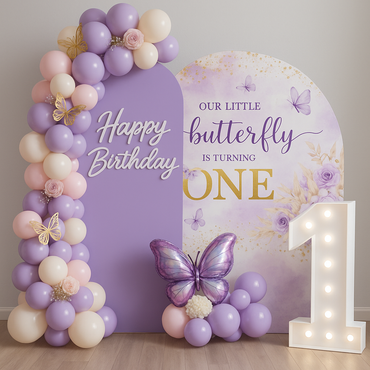 Party decorations with balloons, wood stumps, and a green cabinet in a grassy outdoor setting.