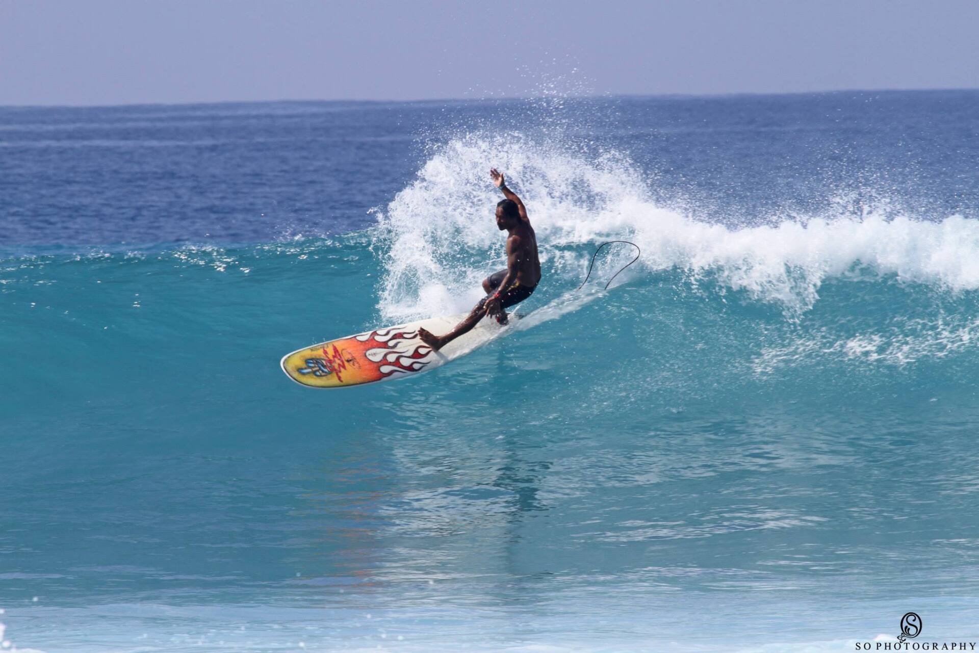 A man is riding a wave on a surfboard in the ocean.