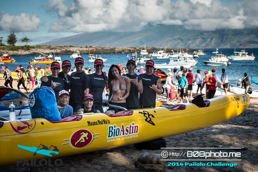 A group of people standing around a yellow boat that says bio4stin