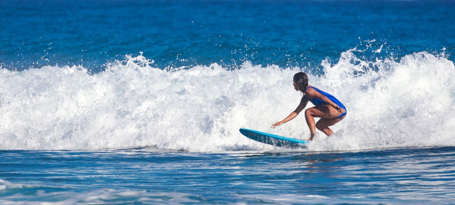 A woman is riding a wave on a surfboard in the ocean.