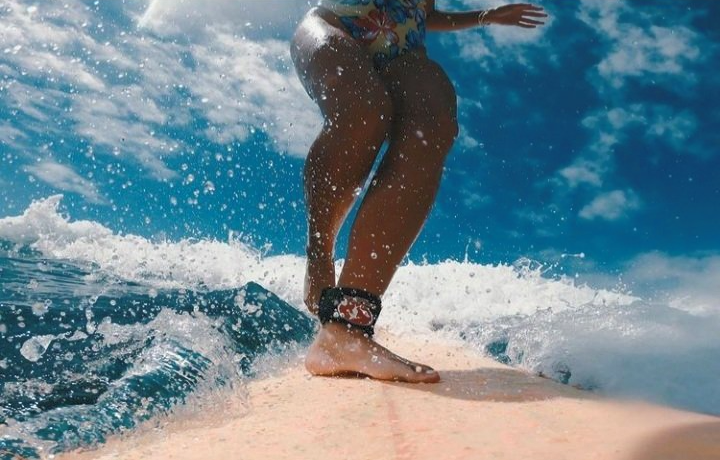 A woman is riding a wave on a surfboard in the ocean.