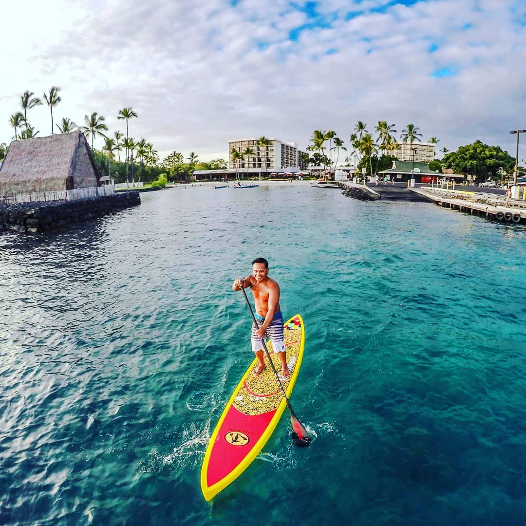 A man is riding a paddle board in the ocean