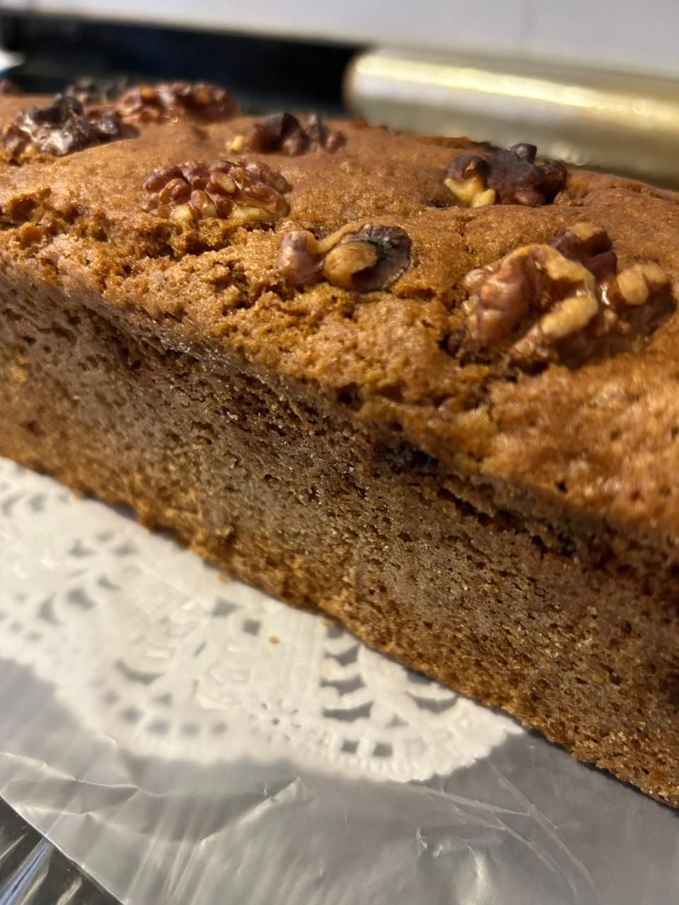 Bizcocho con cobertura de nueces sobre un tapete de papel decorativo.