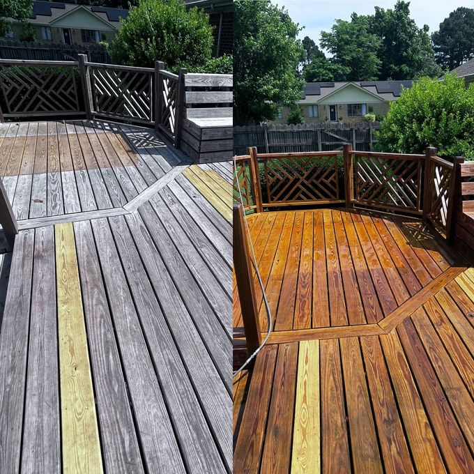 A person is using a high pressure washer to clean a wooden deck.