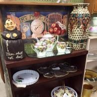 Assorted decorative Halloween-themed items displayed on a wooden shelf in a store.