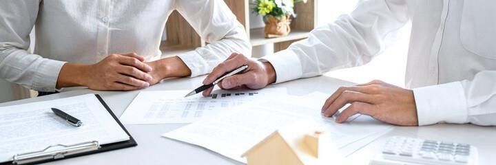 A man and a woman are sitting at a table looking at a piece of paper.