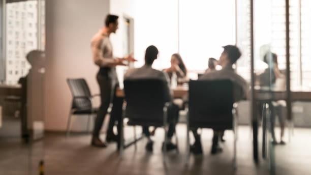 A group of people are sitting around a table in a conference room.