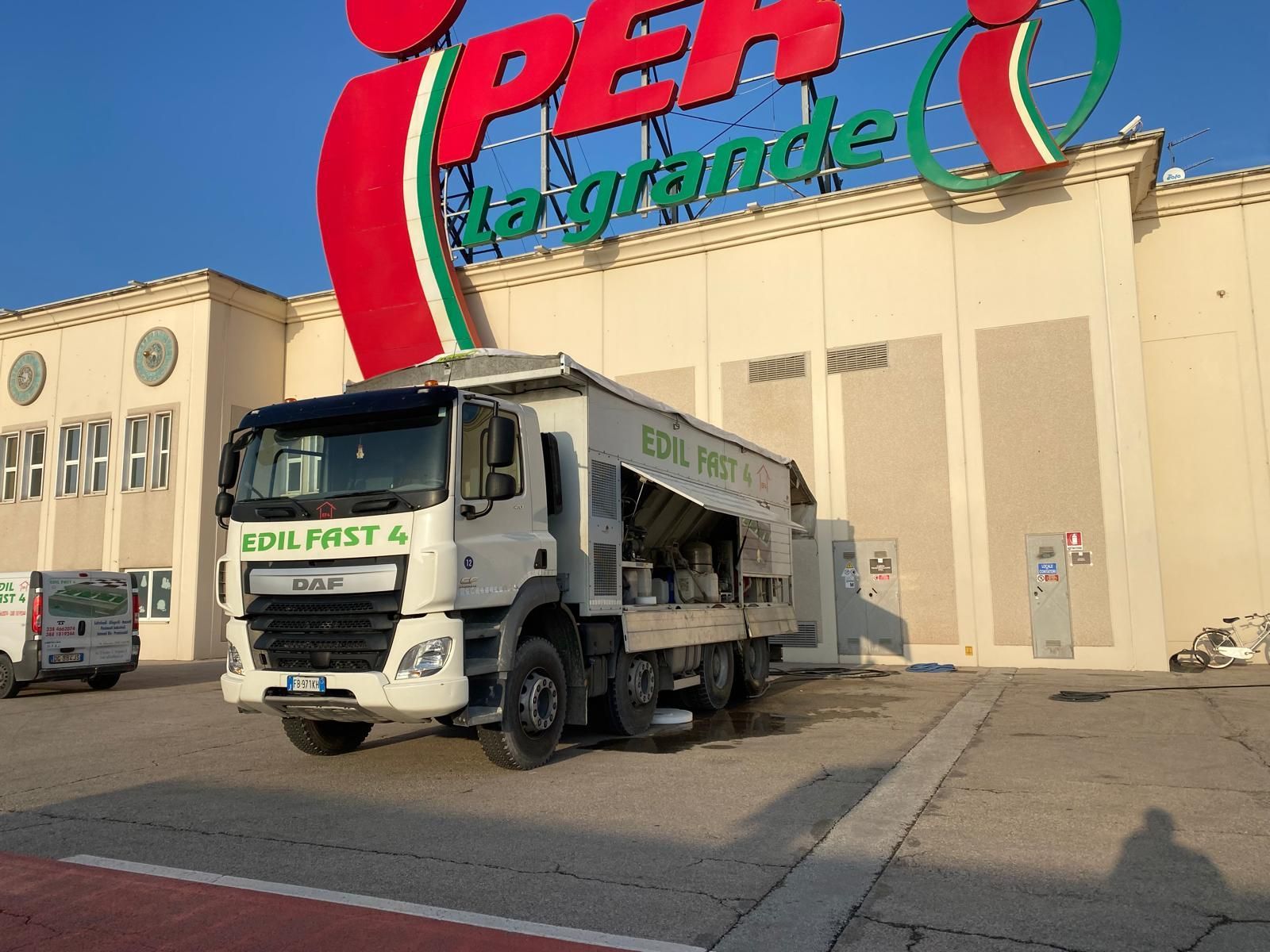 Soggiorno moderno con mensole sospese, TV e vista sulla città di notte.