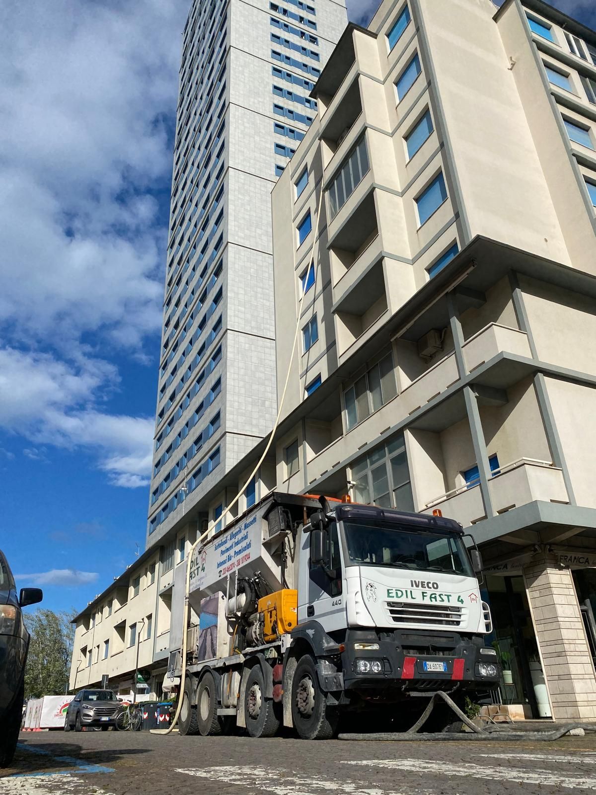 Soggiorno moderno con mensole sospese, TV e vista sulla città di notte.