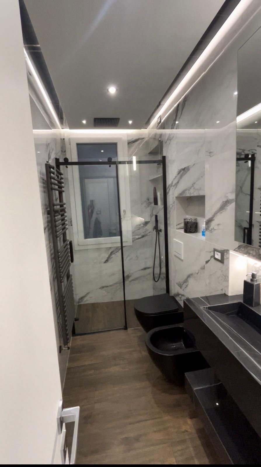 Tubi arancioni e bianchi posati su una superficie scura, parte di un sistema di riscaldamento a pavimento radiante durante l'installazione.