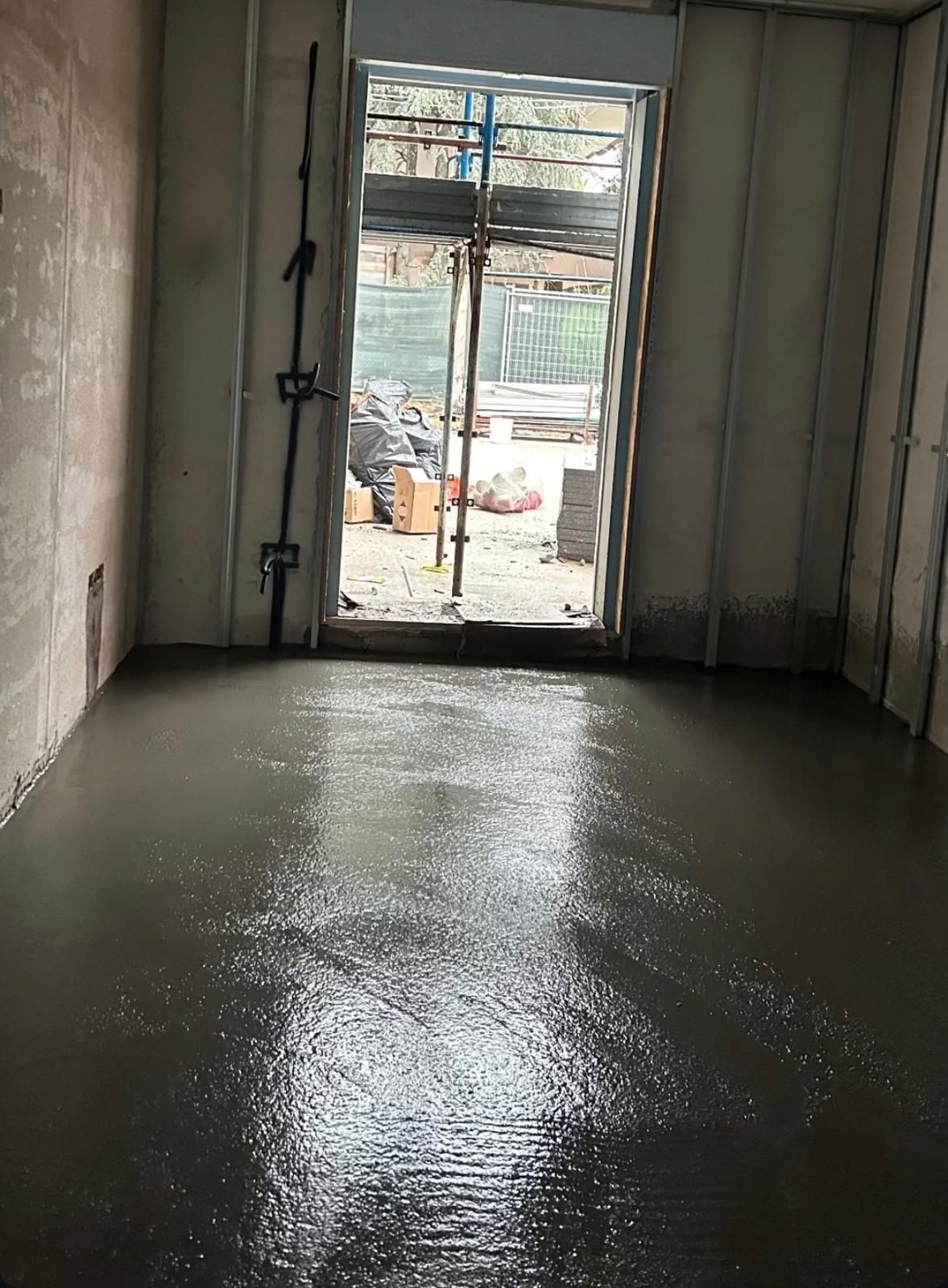 Soggiorno moderno con mensole sospese, TV e vista sulla città di notte.