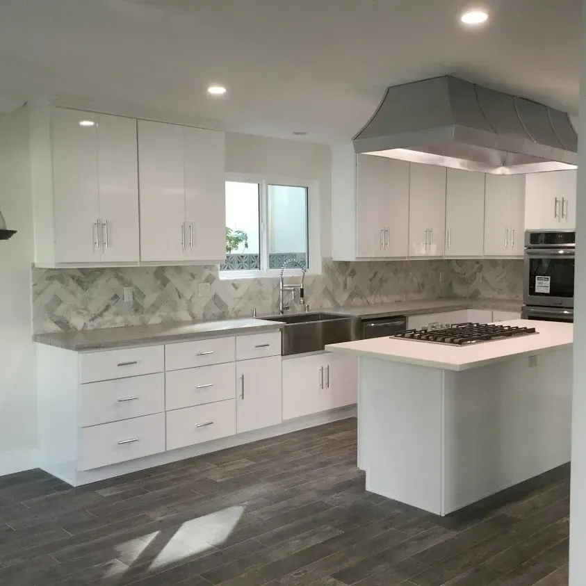 A kitchen with white cabinets and a large island