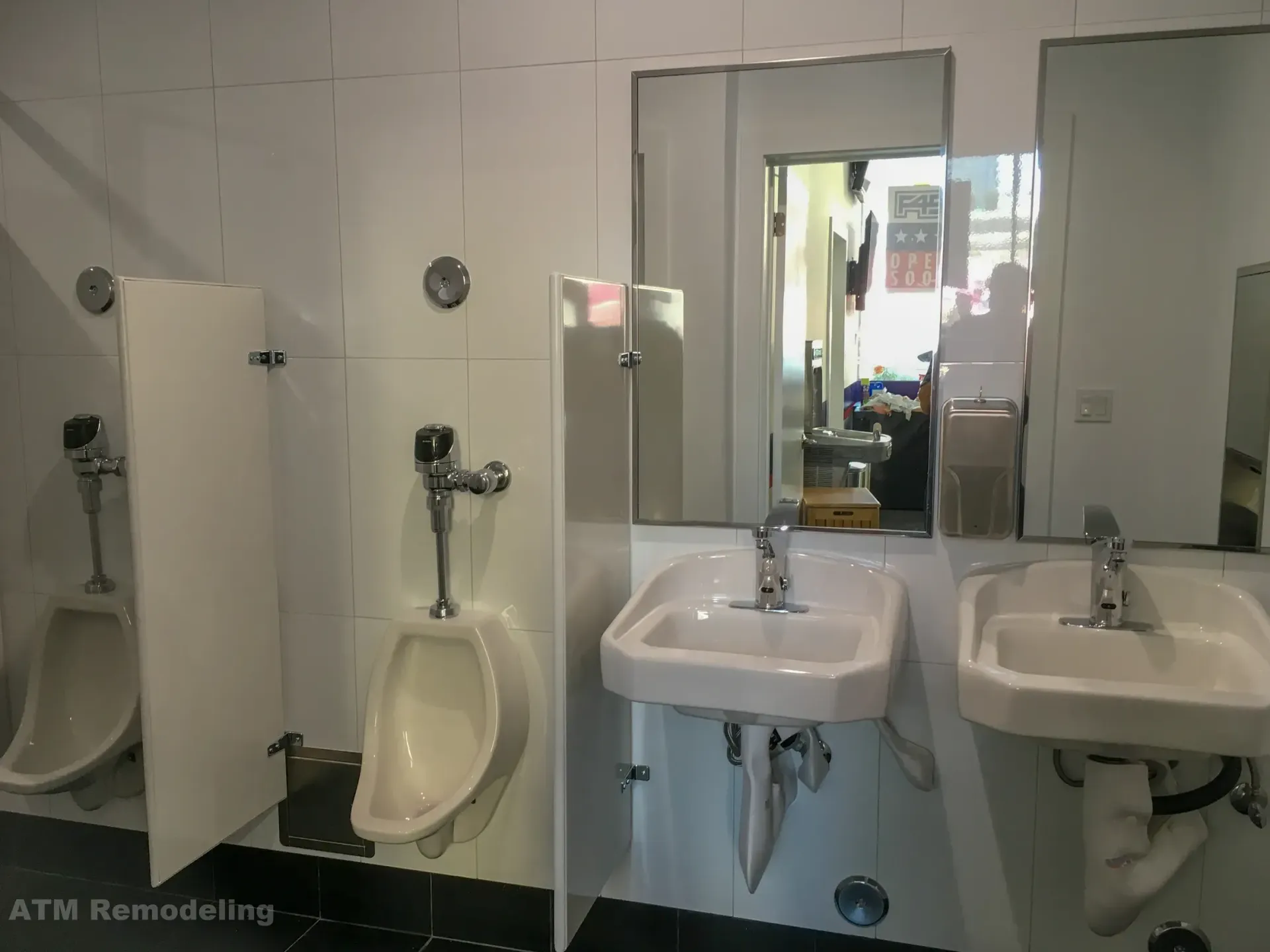A bathroom with two sinks , a urinal and a mirror.