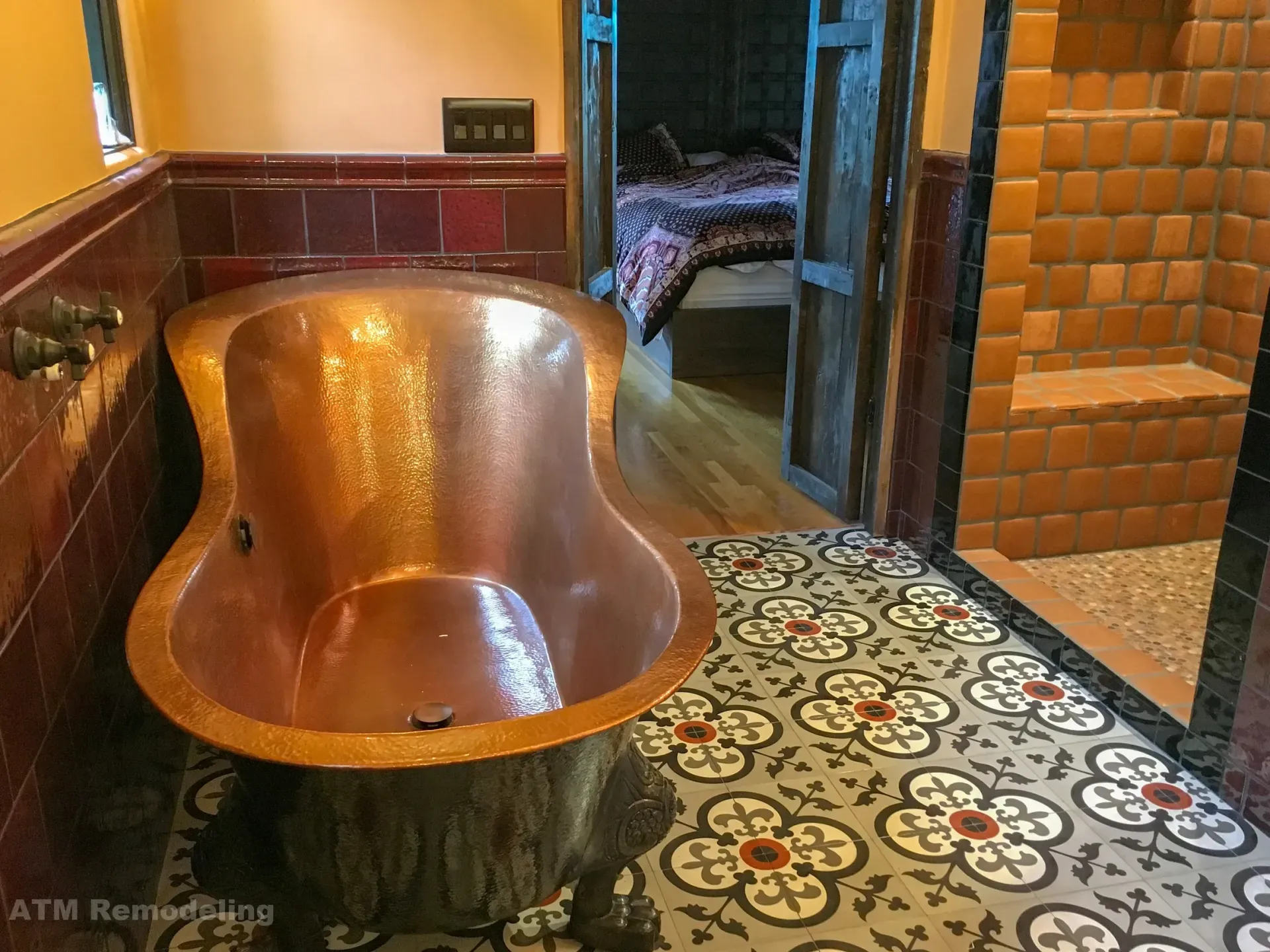 A copper bathtub is sitting on a tiled floor in a bathroom.