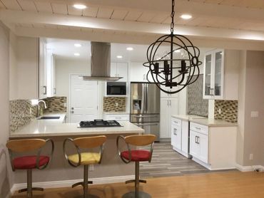 A kitchen with a sink , cabinets , and a window.