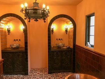 A bathroom with two sinks and a chandelier hanging from the ceiling