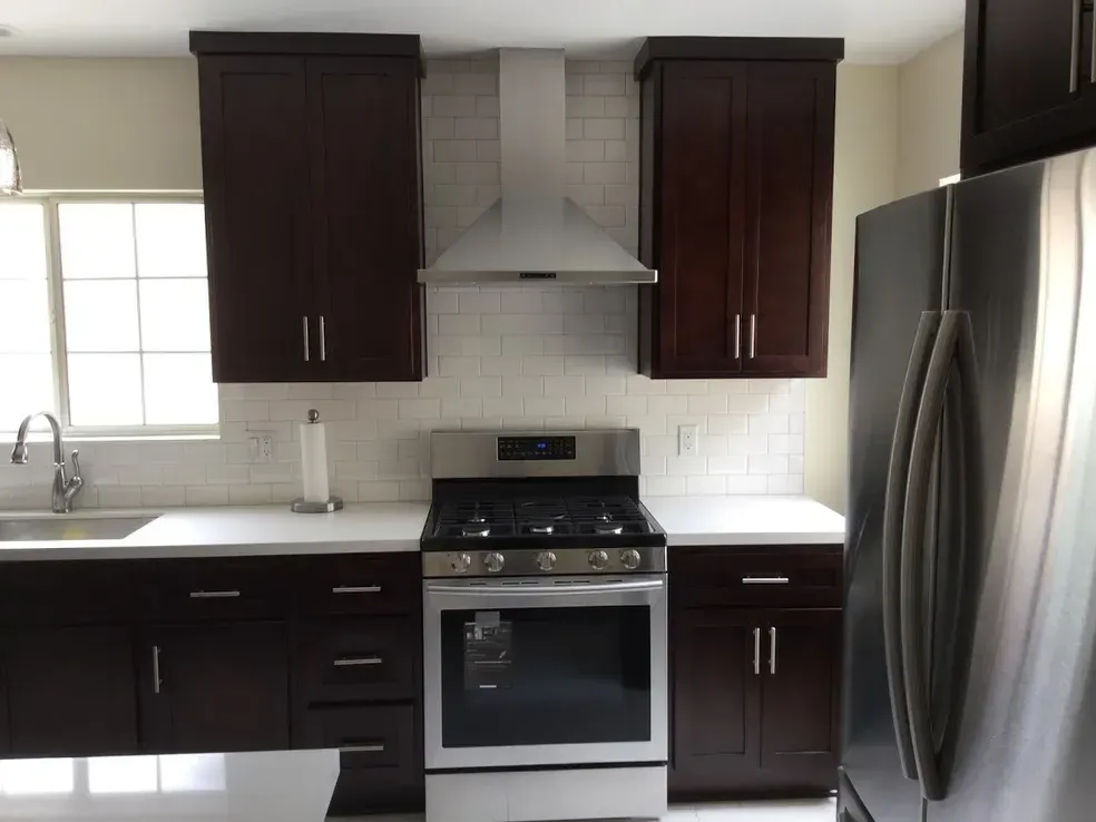 A kitchen with stainless steel appliances and brown cabinets