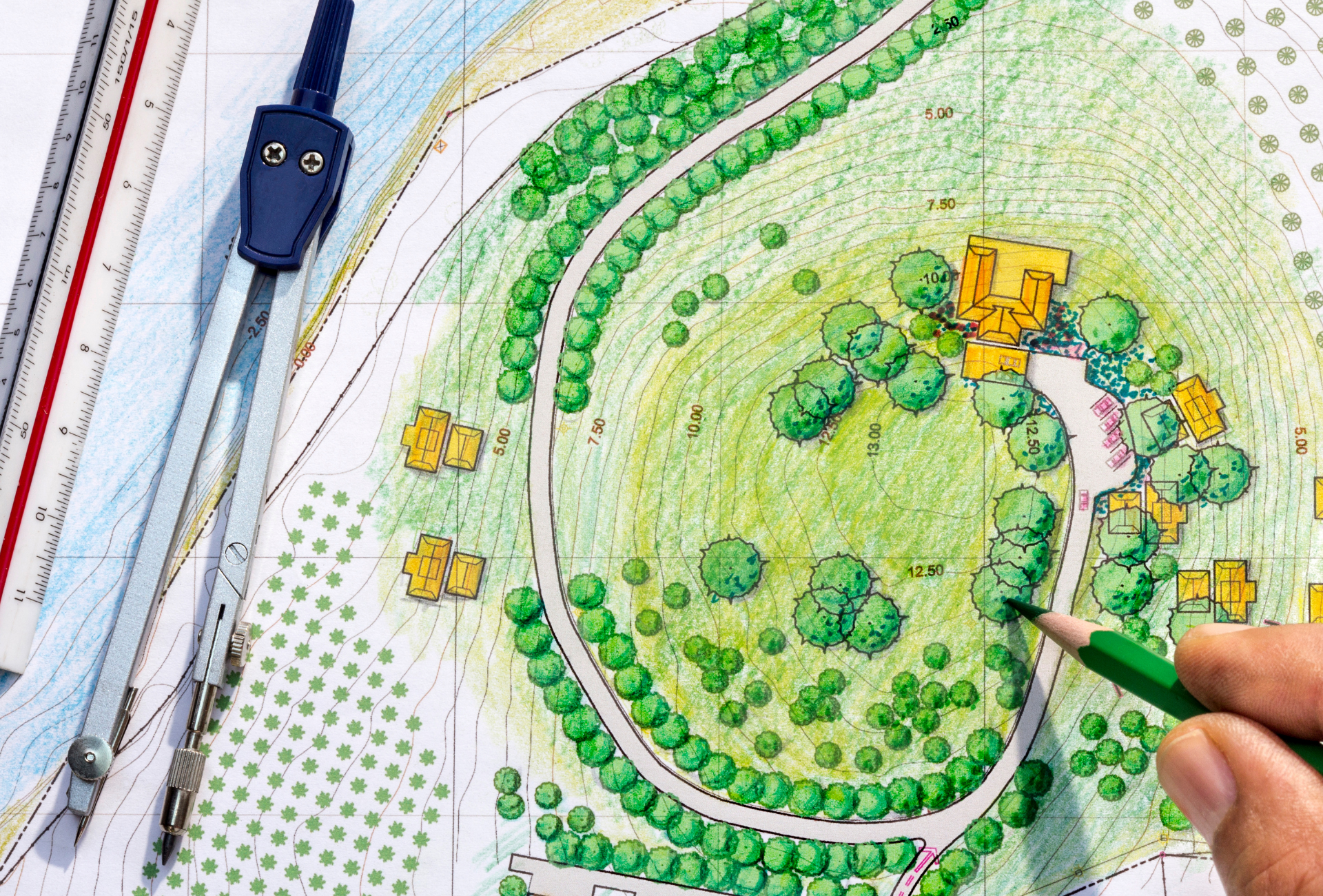 A person is drawing a map of a park with a green pencil.