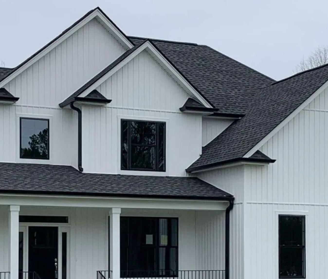 White house with black trim, dark roof, and windows; exterior view.